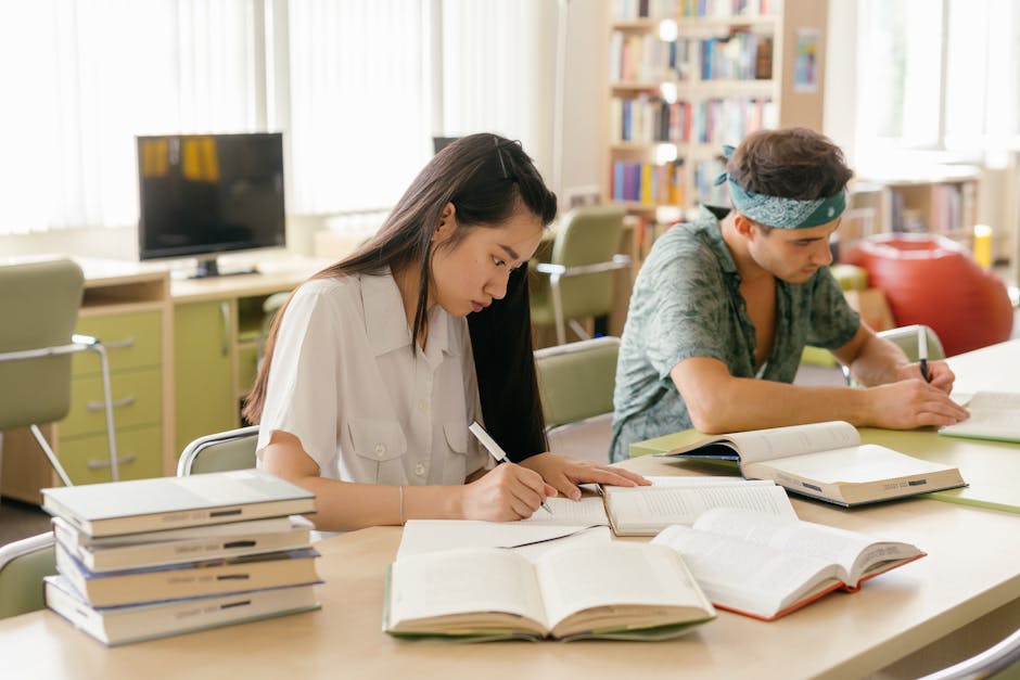 College students studying and taking notes in a library setting.