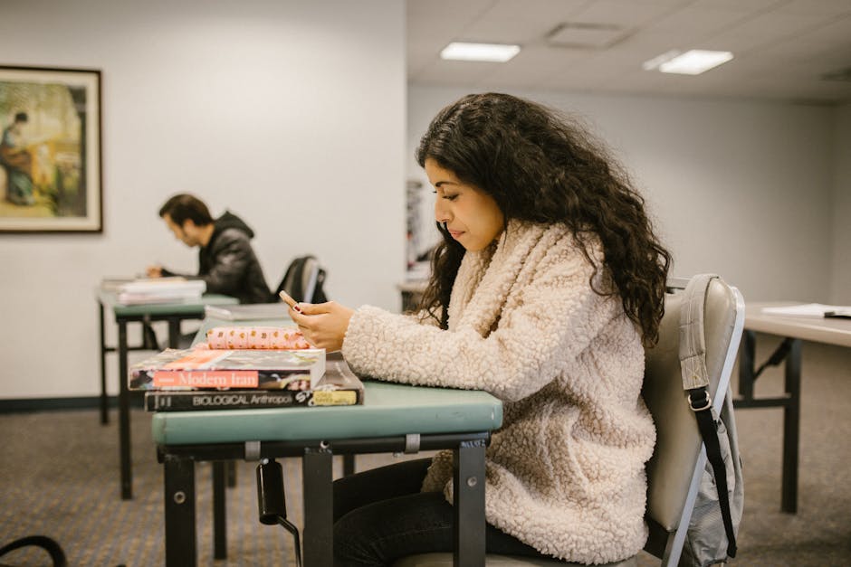 Female college student focusing on study materials in a classroom setting